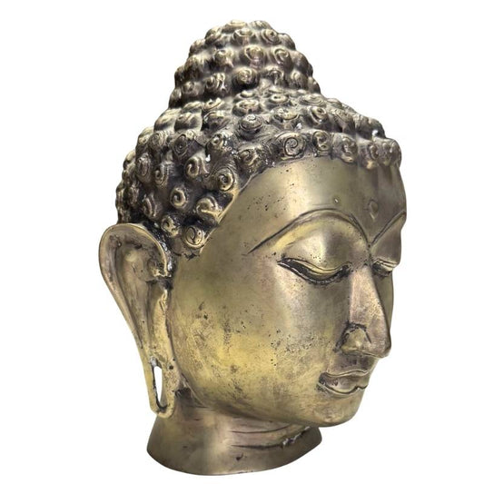 Dreiviertelprofil eines handgegossenen Buddha-Kopfes mit Fokus auf die authentische Patina.