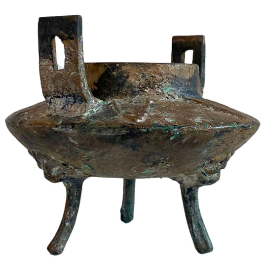 Seitenansicht des eisernen Opfergefäßes mit starken Mineralablagerungen und Patina.
