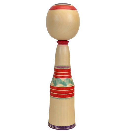Rückansicht der schlanken hölzernen Kokeshi-Puppe, die die reine honiggoldene Maserung des gealterten Mizuki-Holzes und parallele rote Ringe zeigt.