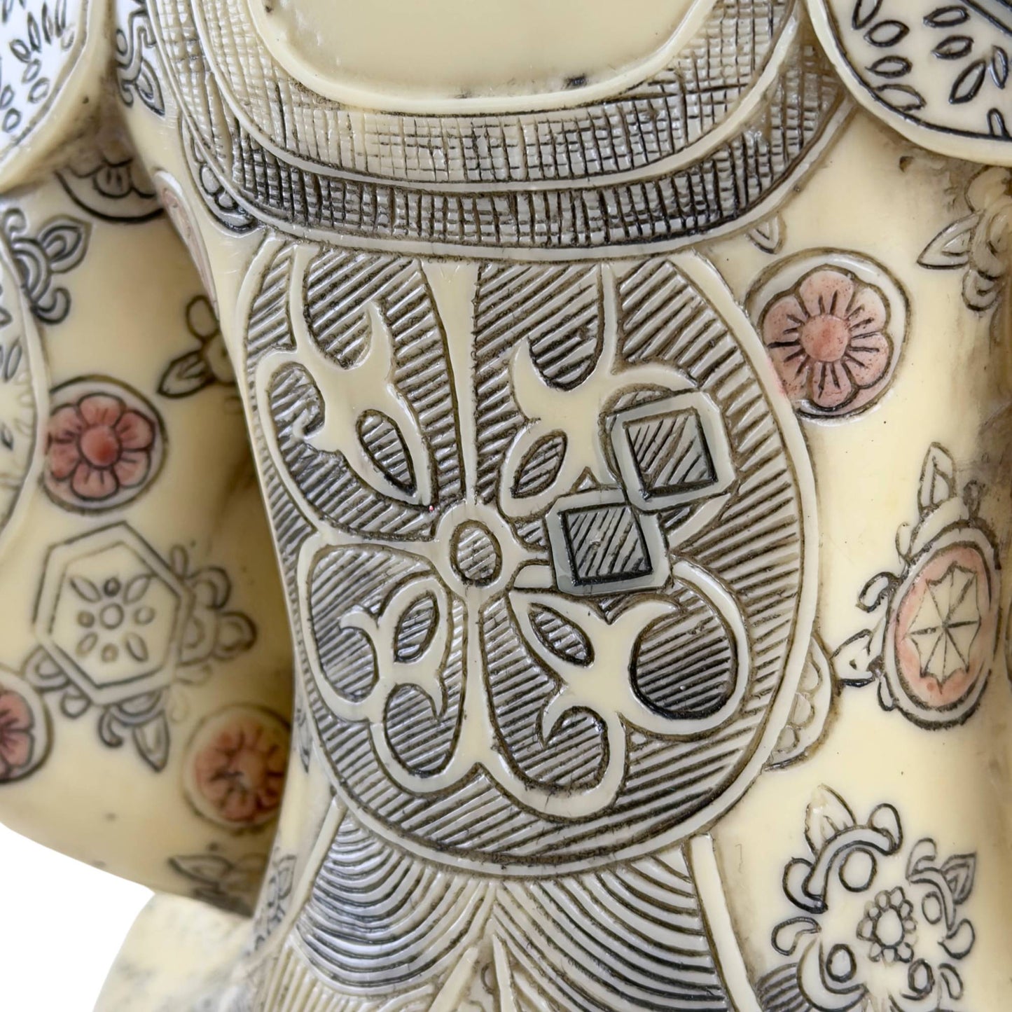 Detail einer thailändischen Buddha-Statue: geometrisches Gewand mit farbigen Blumenmotiven