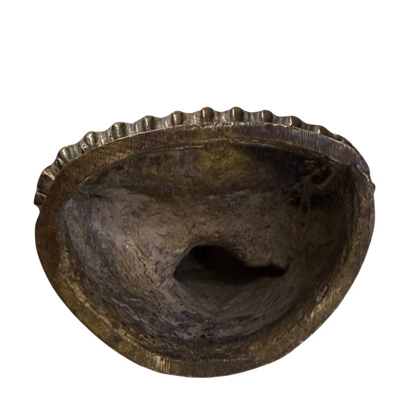 Die Unterseite der Skulptur gibt den rohen Gussprozess frei.