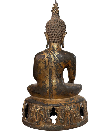 Seitenansicht des Buddha auf dem symbolischen offen gearbeiteten Sockel.
