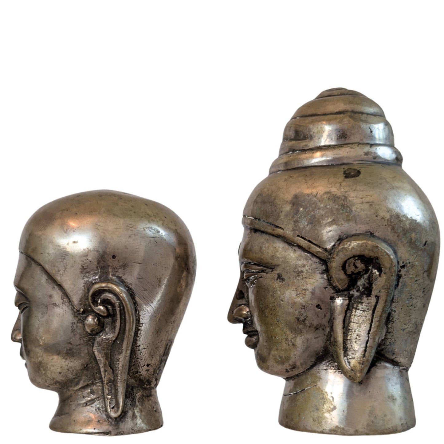 Die Rückseite beider Bronzestatuen, mit Fokus auf die goldbraune Patina.