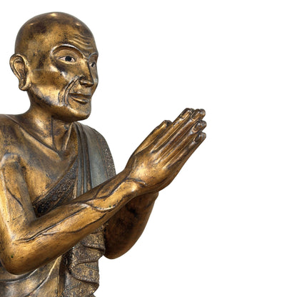Burmesischer Mönch Sariputta aus vergoldetem Holz mit den Händen in Anjali Mudra und ausgeprägten Adern auf dem Unterarm.