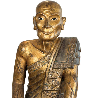 Gesicht der burmesischen Holzstatue des Hauptjüngers Sariputta mit handgeschnitzten Falten und verwittertem Blattgold.