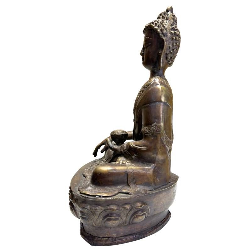 Detail einer antiken Medizinbuddha-Figur aus Bronze mit ruhigem Gesichtsausdruck