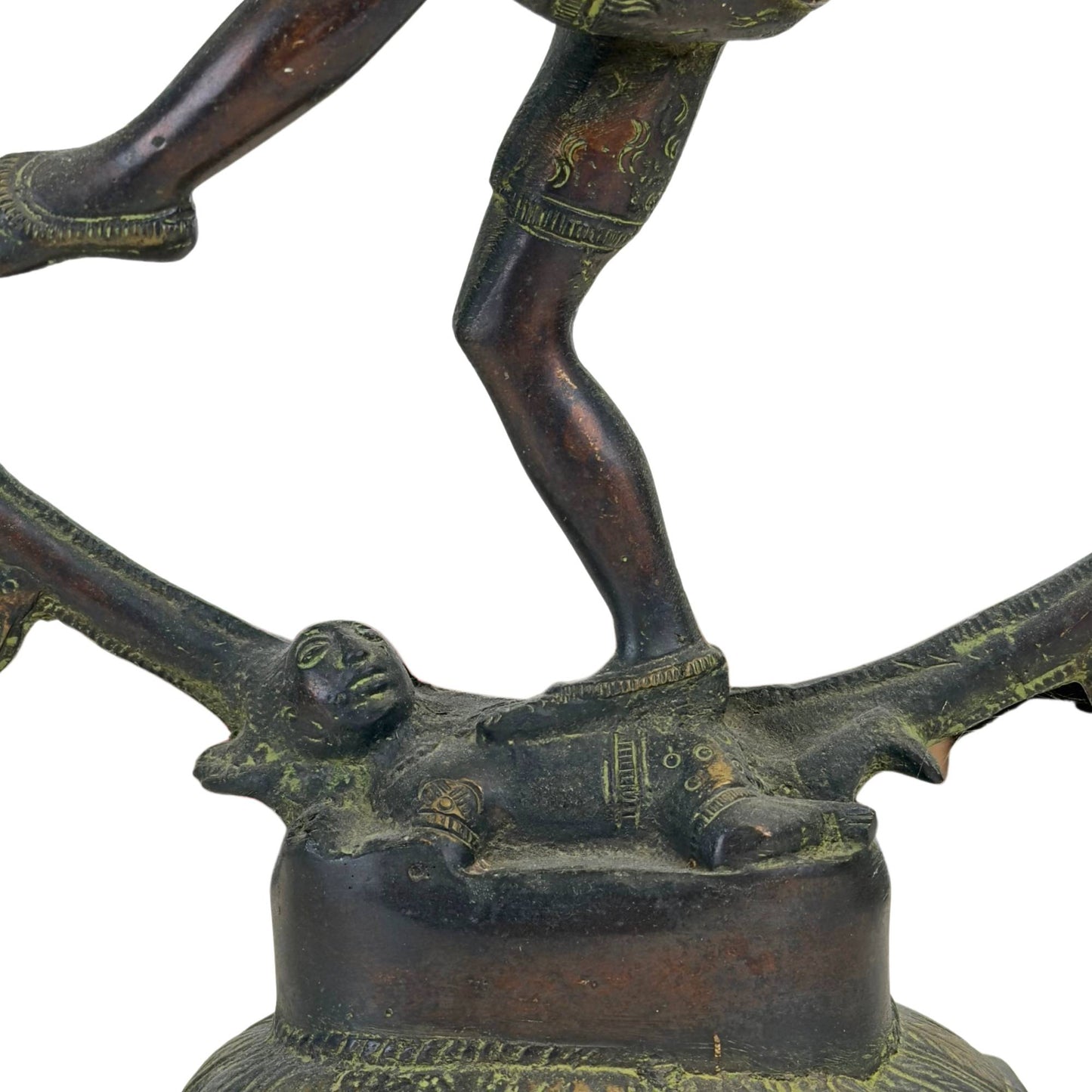 Nahaufnahme des Zwerges Apasmara zu Füßen von Shiva Nataraja auf dem bronzenen Lotussockel