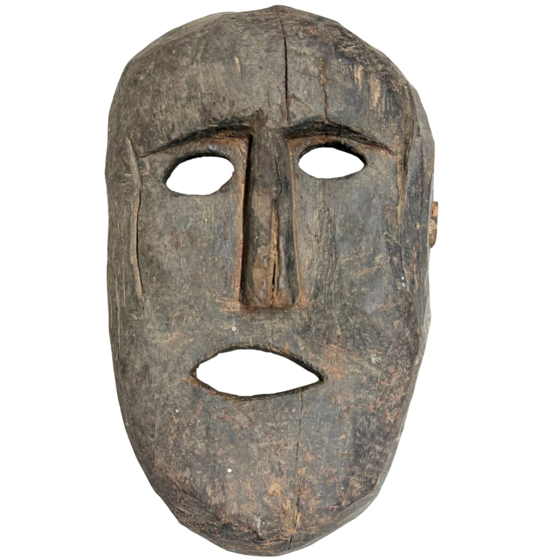 Authentische antike Schamanenmaske aus Holz aus der Himalaya-Region, primitiv handgeschnitzt mit einer tiefen Patina der Abnutzung.