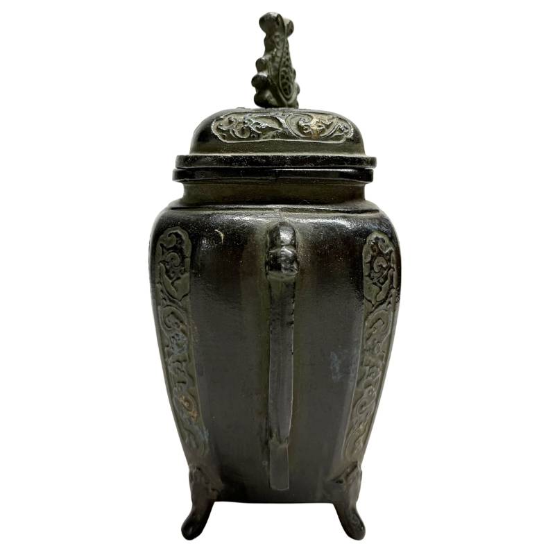 Seitenansicht des japanischen Bronzebrenners, wobei der gegossene Griff und die tief schwarzbraune Patina besonders hervorgehoben werden.