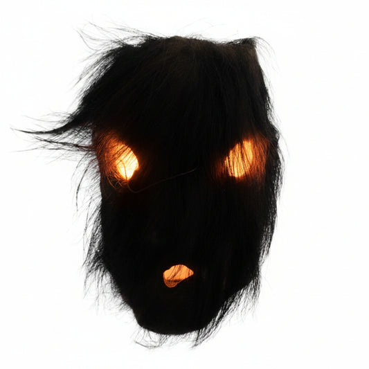 Direkter Blick auf die rituelle Maske aus Nepal mit dem dichten Haar aus organischem schwarzem Yakhaar über den Augen- und Mundöffnungen.