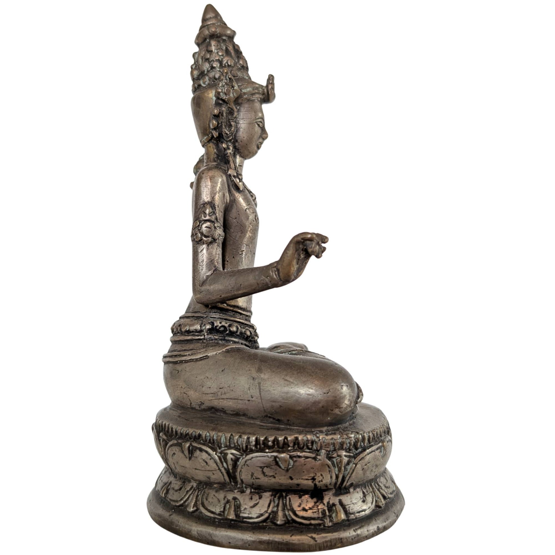 Die Seitenansicht hebt den zarten Lotusstängel hervor, der am Arm des Bodhisattva entlangwächst.
