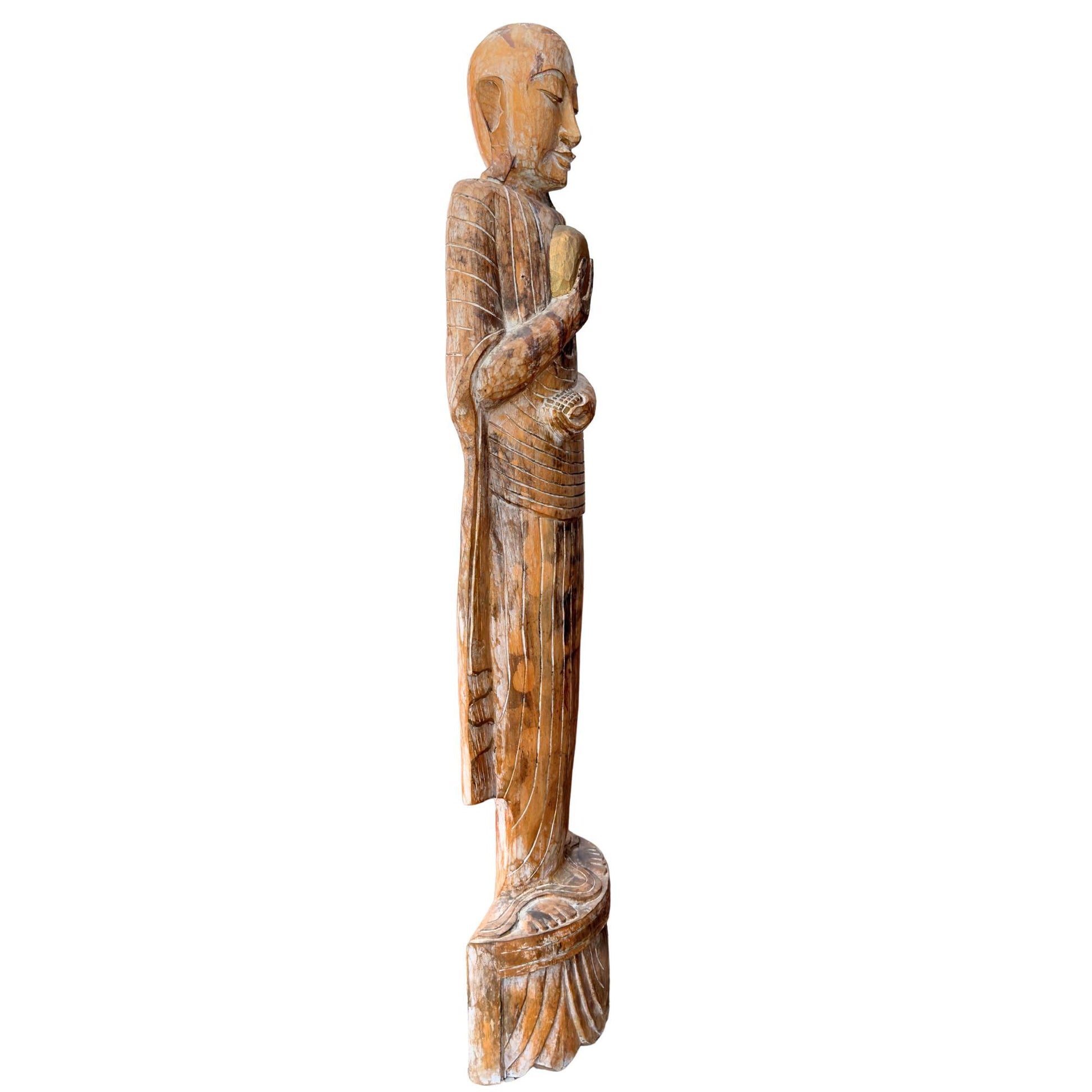 Schlanke Profilansicht der monumentalen buddhistischen Mönchsstatue mit der brutalen, puristischen Wabi-Sabi-Holzstruktur