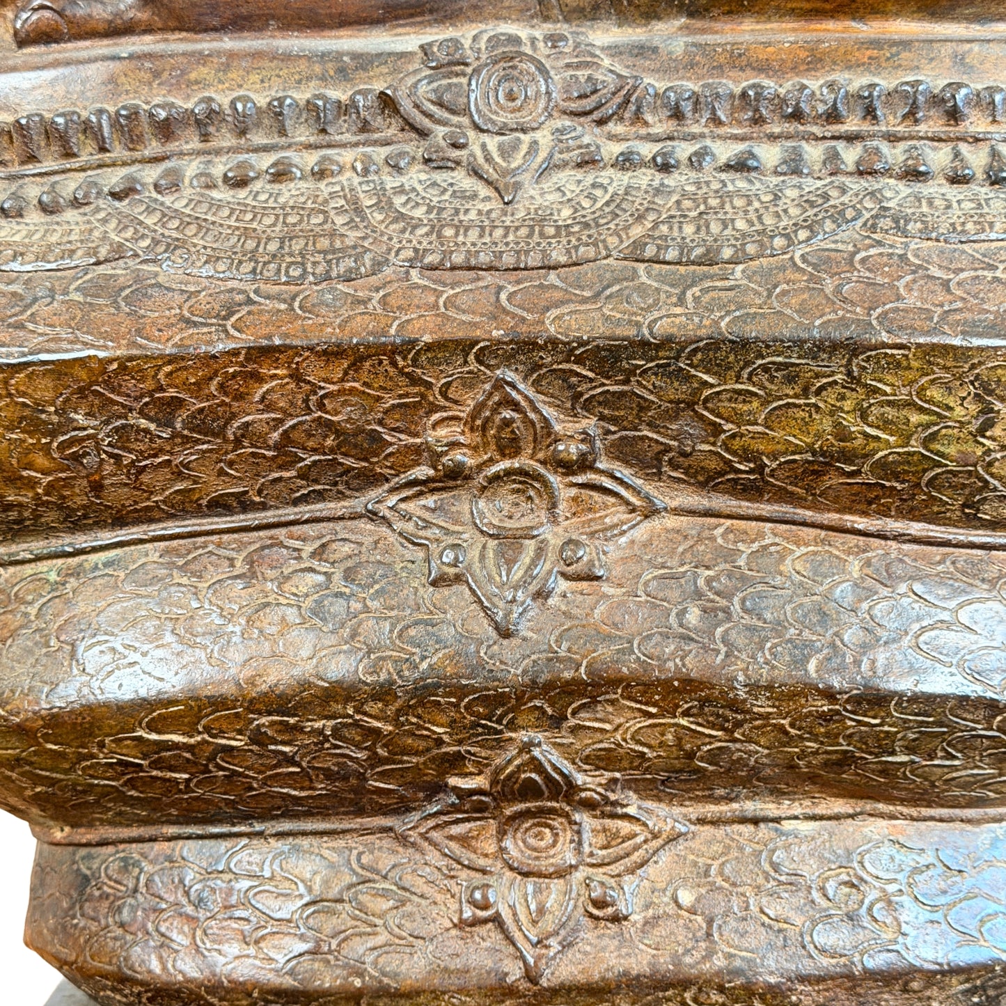 Detail der reich dekorierten Naga-Windungen mit Schuppenmuster, floralen Reliefs und historisch gewachsener brauner Patina