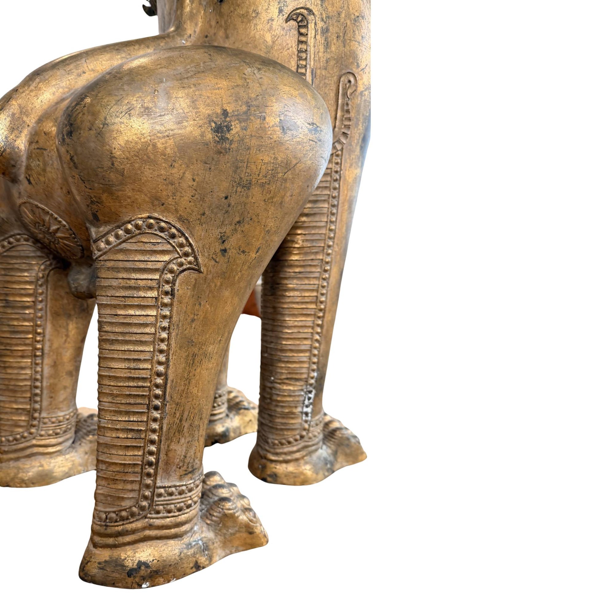Antike thailändische Wächterstatue eines Singha-Löwen, reich vergoldet und zum Schutz buddhistischer Tempel gefertigt.