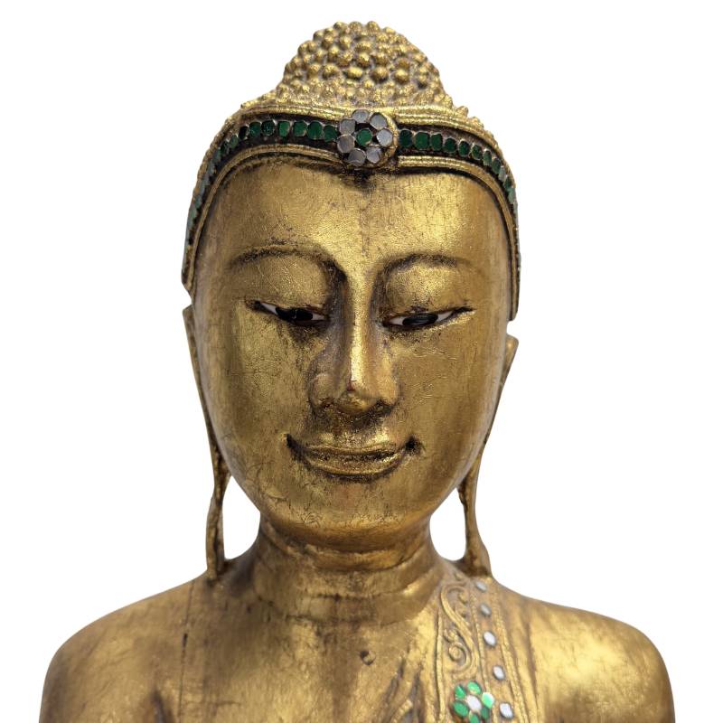 Nahaufnahme des heiteren Gesichts des Buddha von Mandalay, die das breite Stirnband (Pata) mit der zentralen Blumenrosette direkt über den Augenbrauen zeigt.