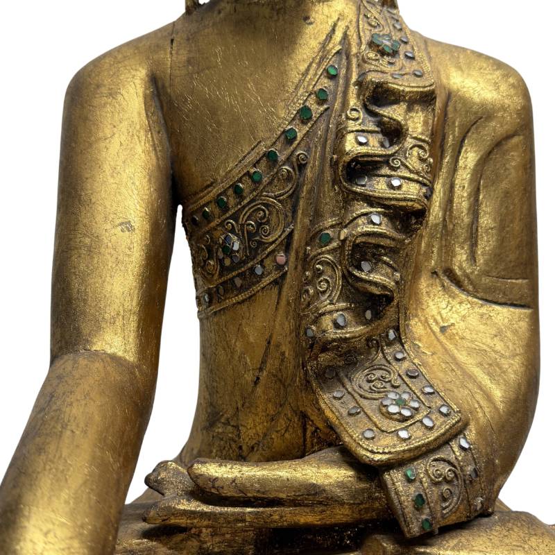 Nahaufnahme des Torsos mit den stark geschichteten Falten der Robe des Civara-Mönchs, die aus detailliertem, verziertem Thayo-Lackrelief und Spiegelglasmosaik besteht.