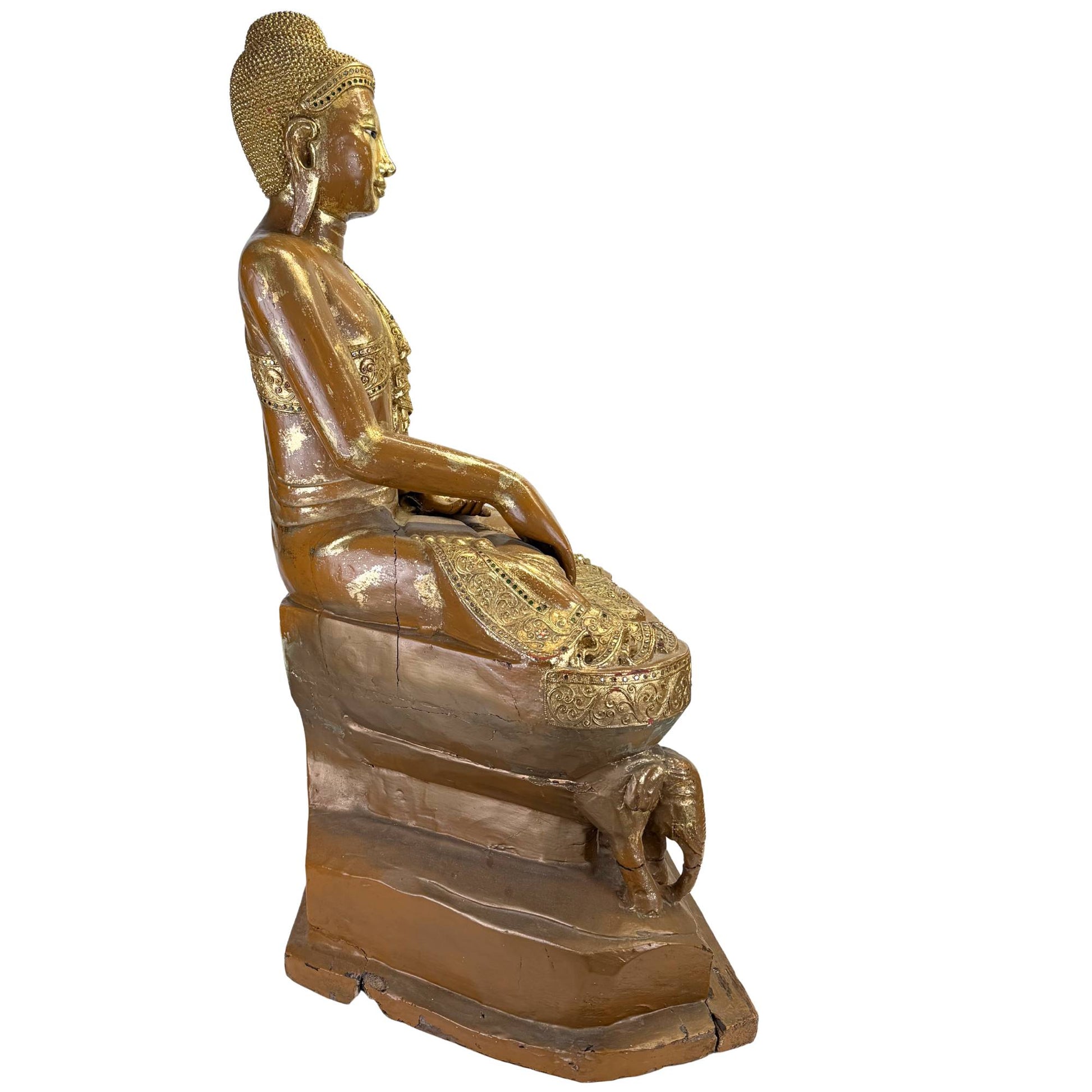 Seitenansicht eines antiken burmesischen Buddha auf einem hohen Thron mit Elefantenmotiven, Goldlack und alten Trocknungsrissen.