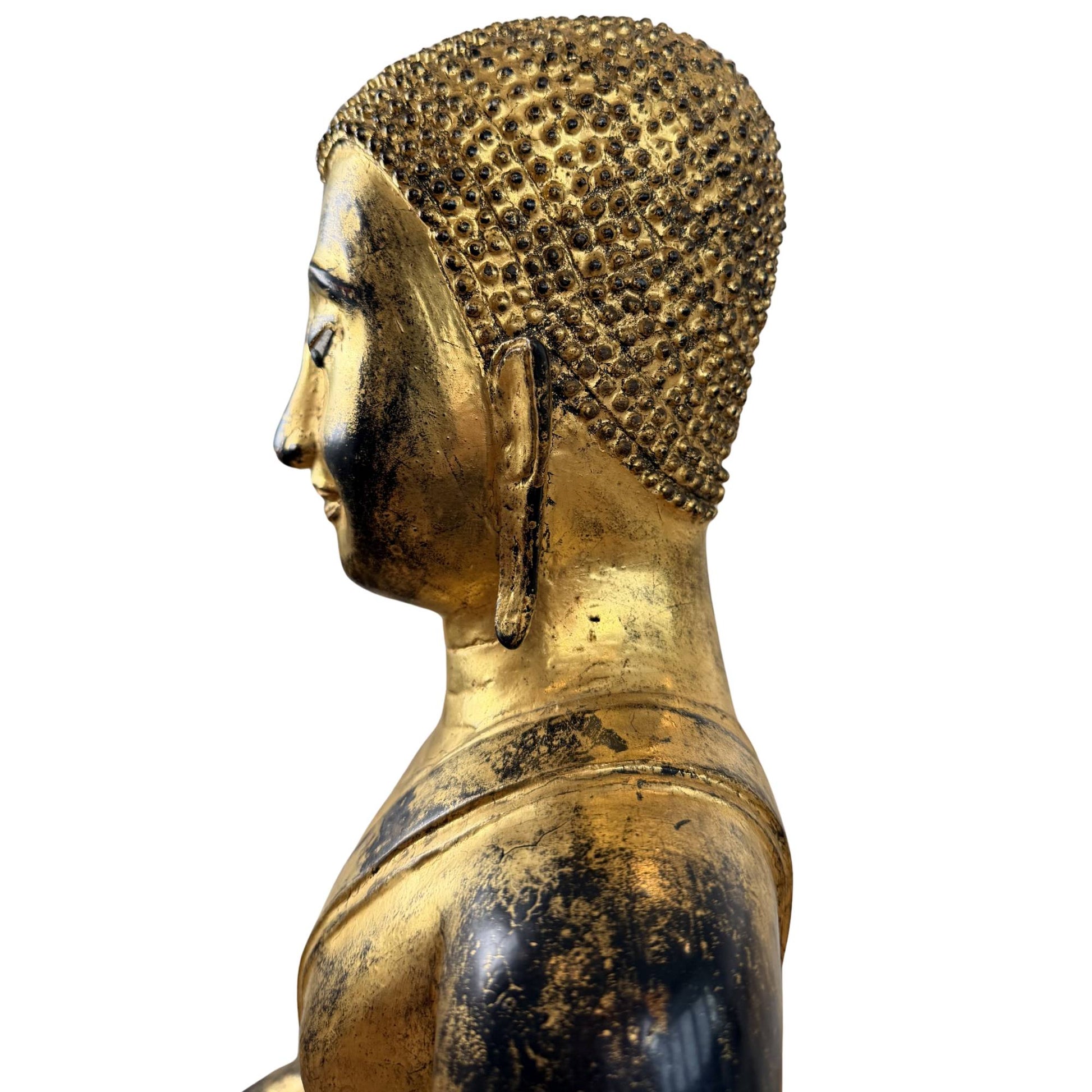 Gesichtsdetail einer antiken Buddha-Statue aus Bronze mit eingelegten Augen, heiterem Lächeln und feuervergoldeter Oberfläche