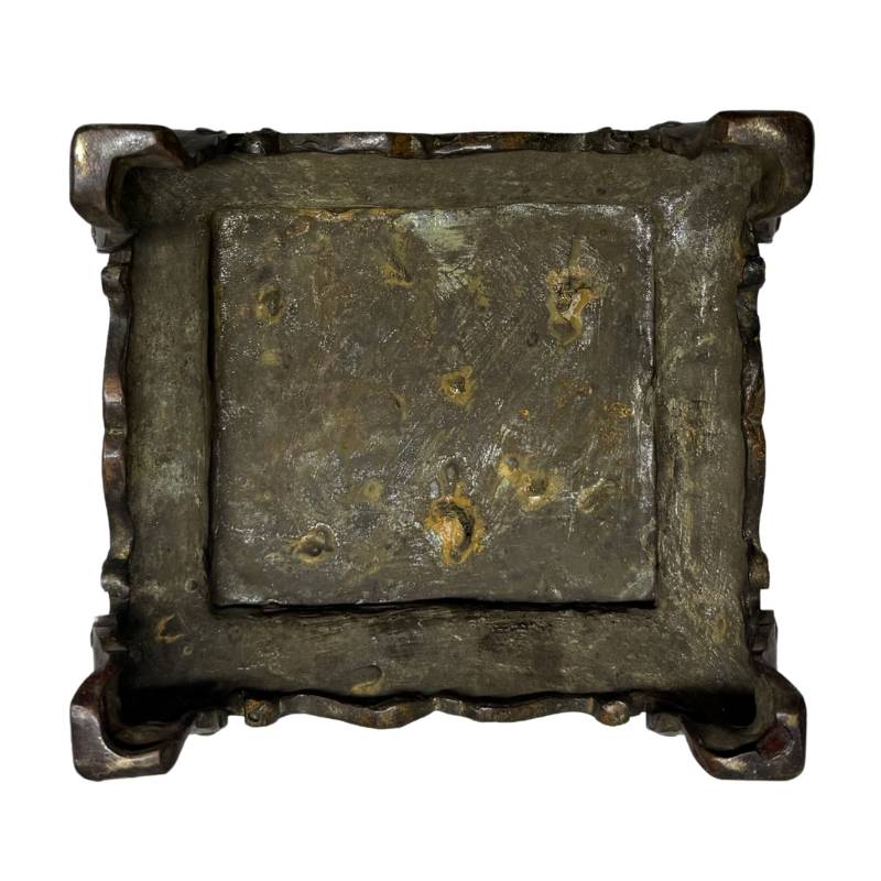 Unterseite des separaten Präsentationssockels aus Bronze, auf der die originalen Gussspuren des Wachsausschmelzverfahrens und die tief eingebrannte Malachitoxidation zu sehen sind.