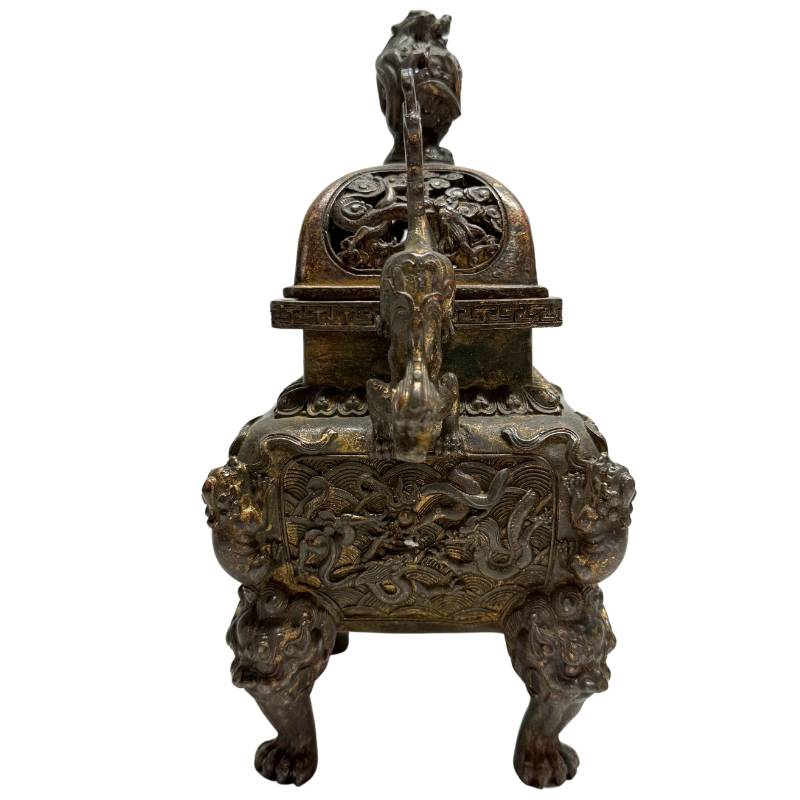 Ansicht von links des Bronzegusses aus der Qing-Dynastie mit der tiefen, historisch bedingten Patina und den feuervergoldeten Resten im Relief.