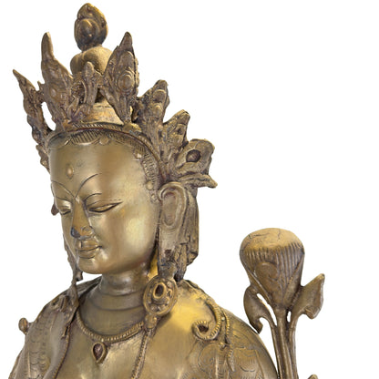 Detail des ruhigen Gesichts, der Krone und der Lotusblüte einer antiken feuervergoldeten Grünen Tara aus Nepal.