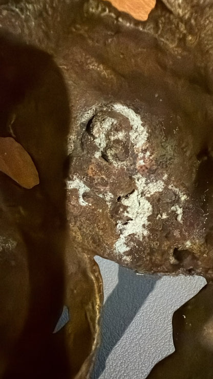 Detail einer alten weißen Mineralablagerung auf einer antiken Grünen Tara aus Nepal, entstanden durch lang anhaltende natürliche Verwitterung der Bronze.