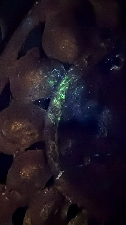 UV‑Foto von einer antiken Grünen Tara aus Nepal mit sichtbarer Fluoreszenz, Feuervergoldung, alten Restaurierungen und natürlicher Patina unter ultraviolettem Licht.