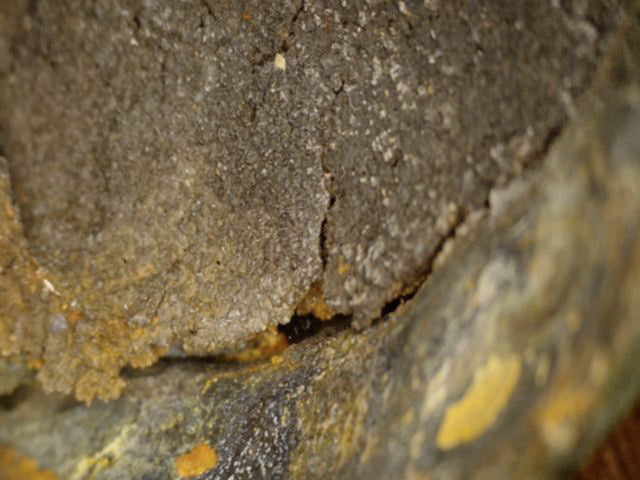 Mikroskopdetail des gerissenen Ton- und Sandgusskerns in der hohlen Unterseite