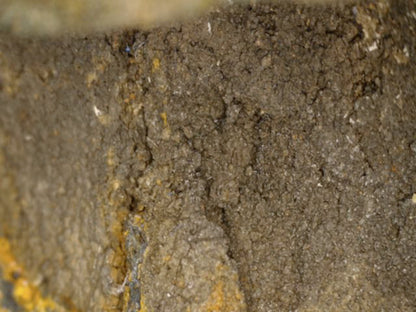 Mikroskopdetail des mineralisierten originalen Gusskerns mit alten Rissen