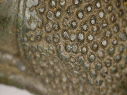 Mikroskopdetail der Haarkringel und natürlichen Abnutzung am antiken thailändischen Bronze-Buddha