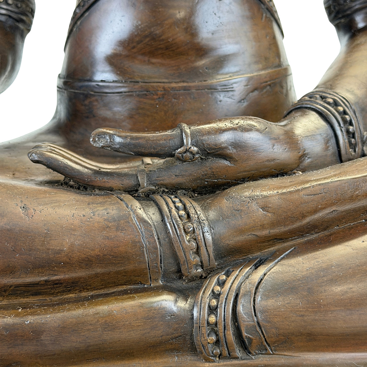 Detail of the left hand resting in the lap of the crowned Buddha