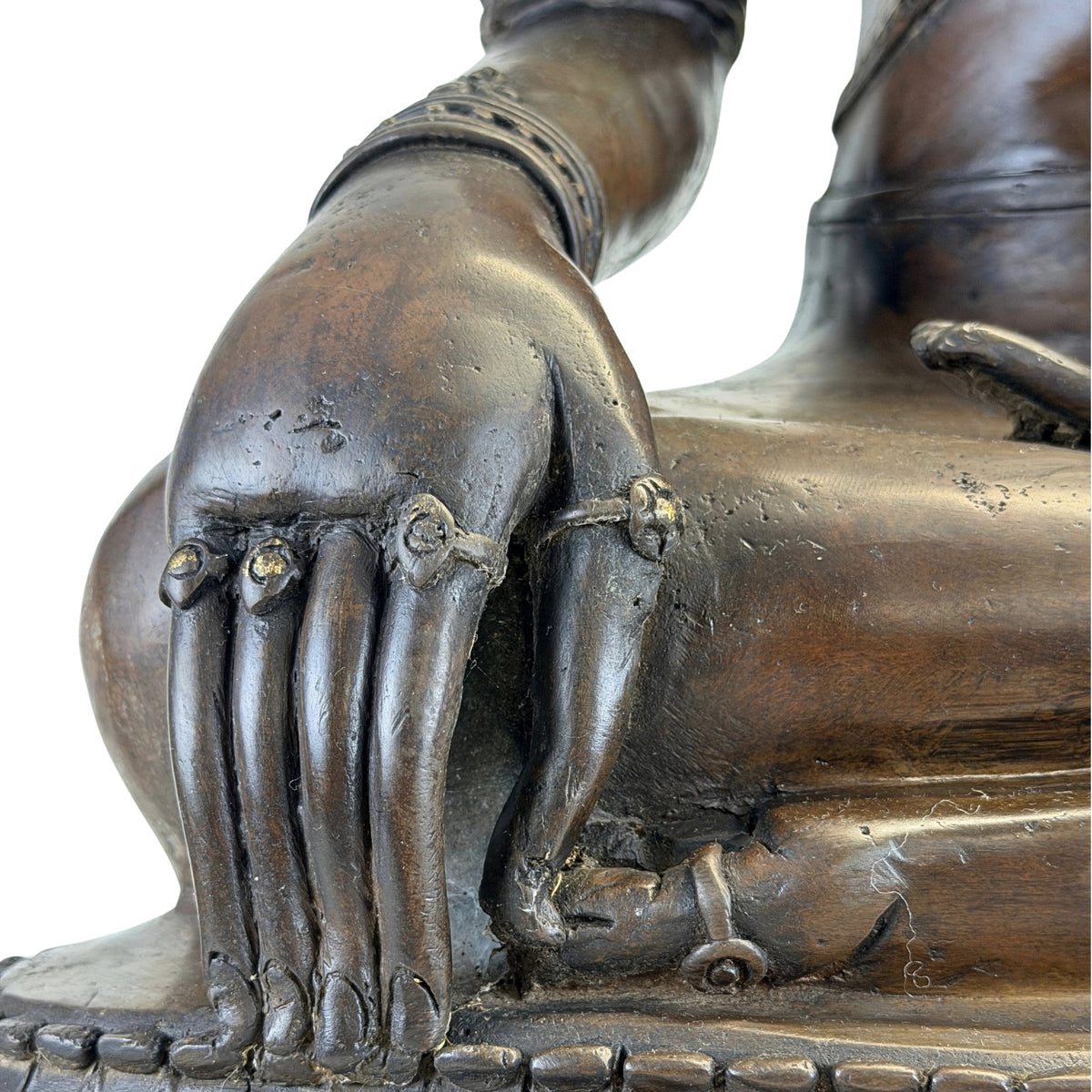 Detail of fingers and hand jewellery on the antique Thai bronze Buddha