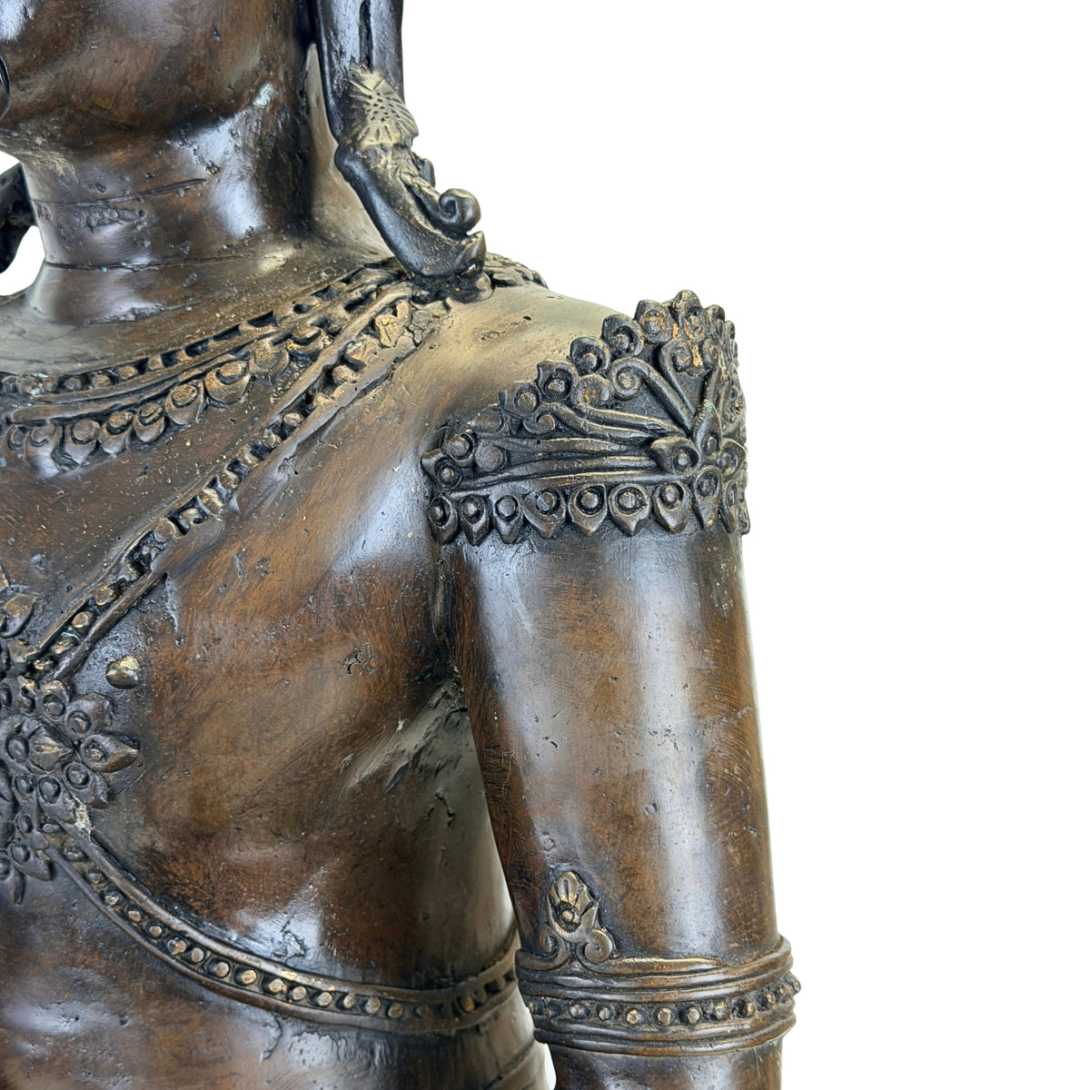 Detail of the left shoulder ornament on the antique Thai crowned Buddha