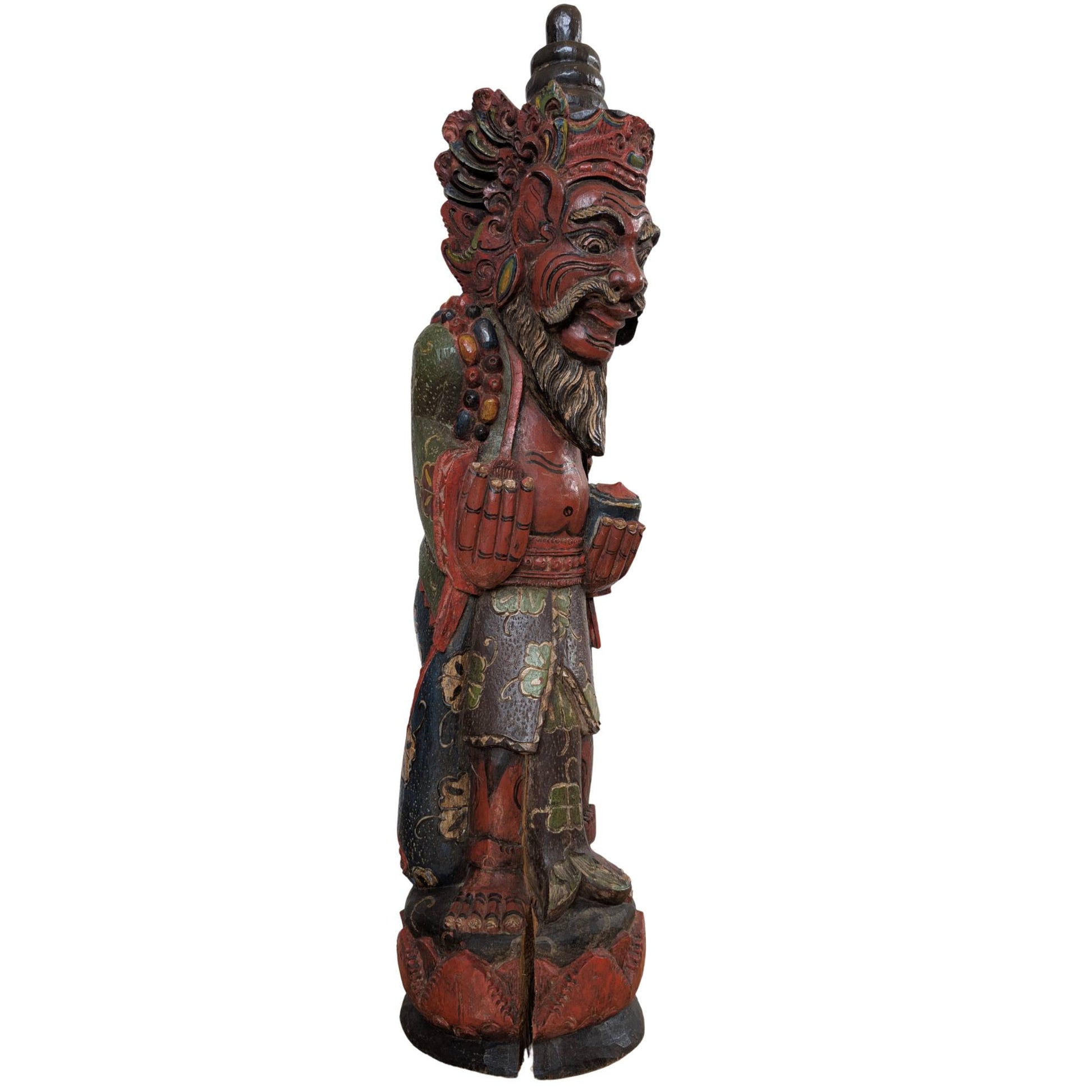 Seitenansicht einer polychrom bemalten balinesischen Tempelwächterstatue.