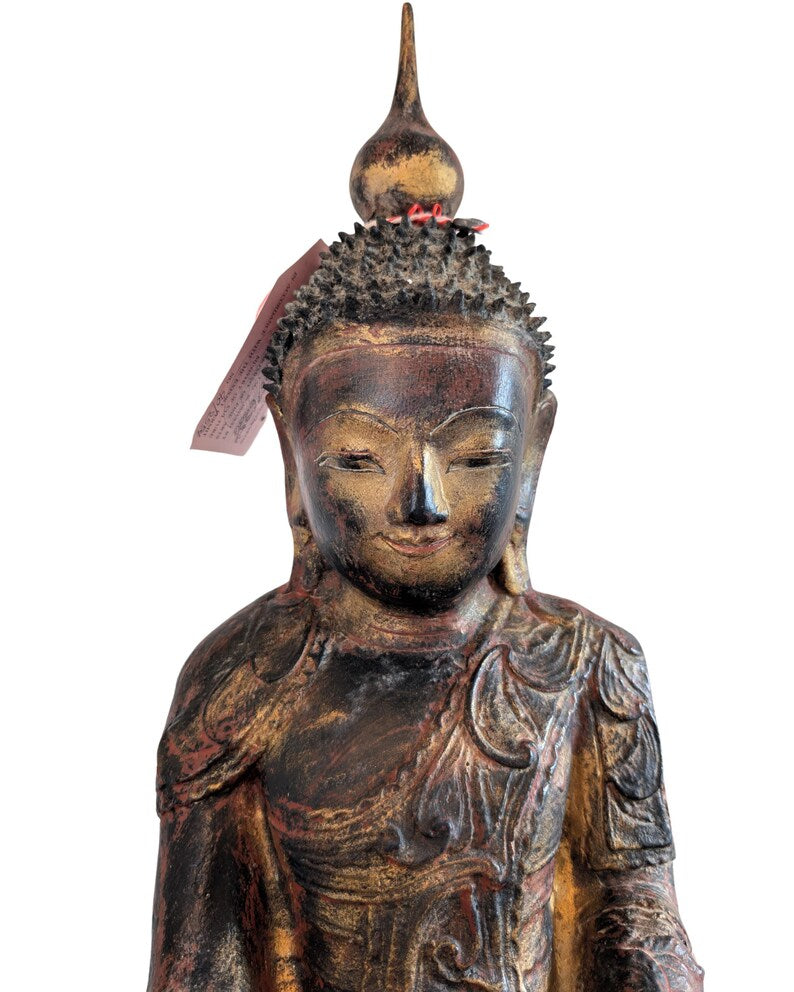 Detail von Gesicht und Oberkörper der antiken burmesischen Buddhafigur mit Etikett