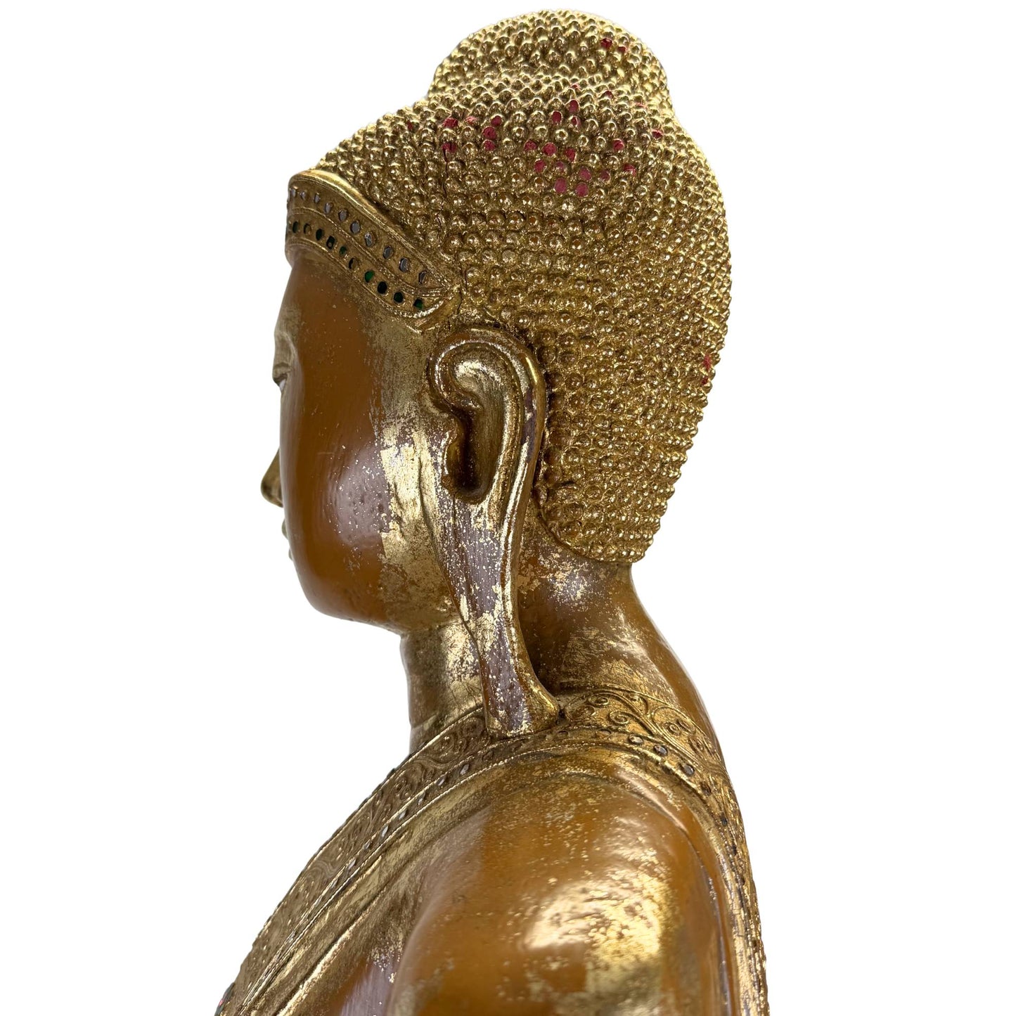 Detail eines antiken burmesischen Buddhas mit fein geschnittenen goldenen Haarlocken und Resten von rotem Pigment.