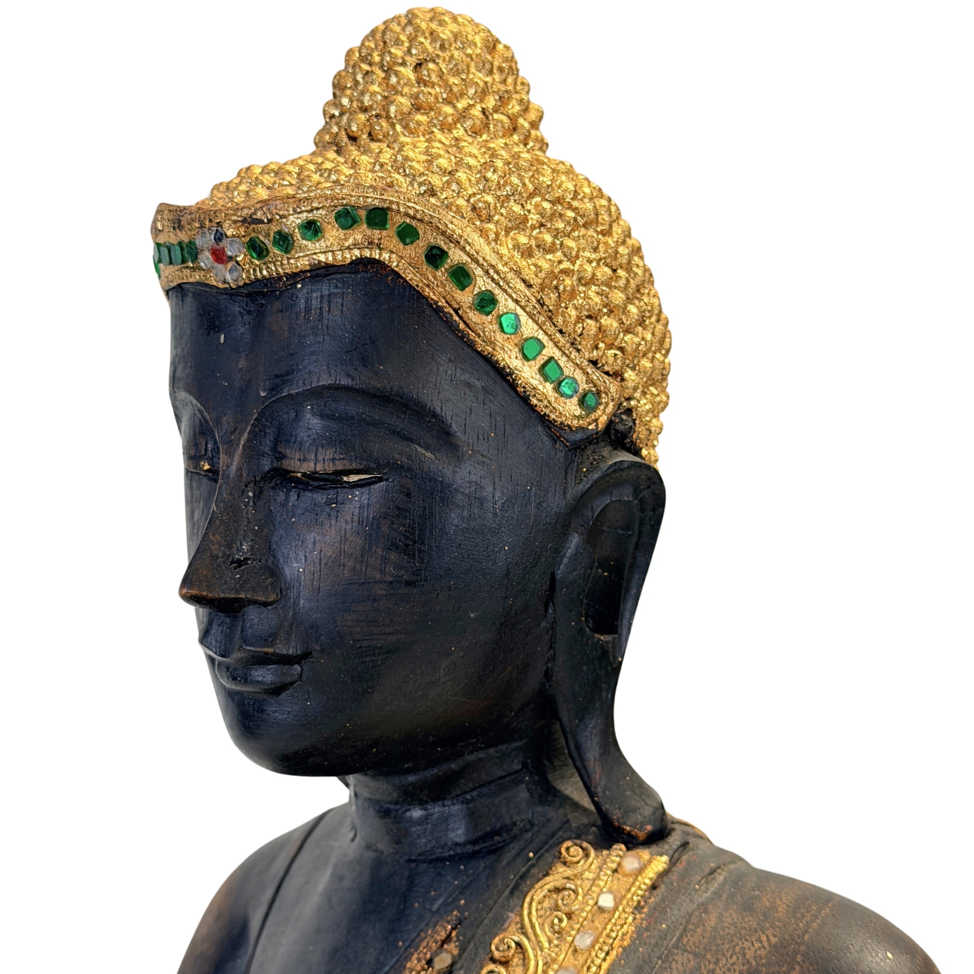 Nahaufnahme des Buddha-Gesichts mit vergoldeten Haarlocken und grüner Glaseinlage