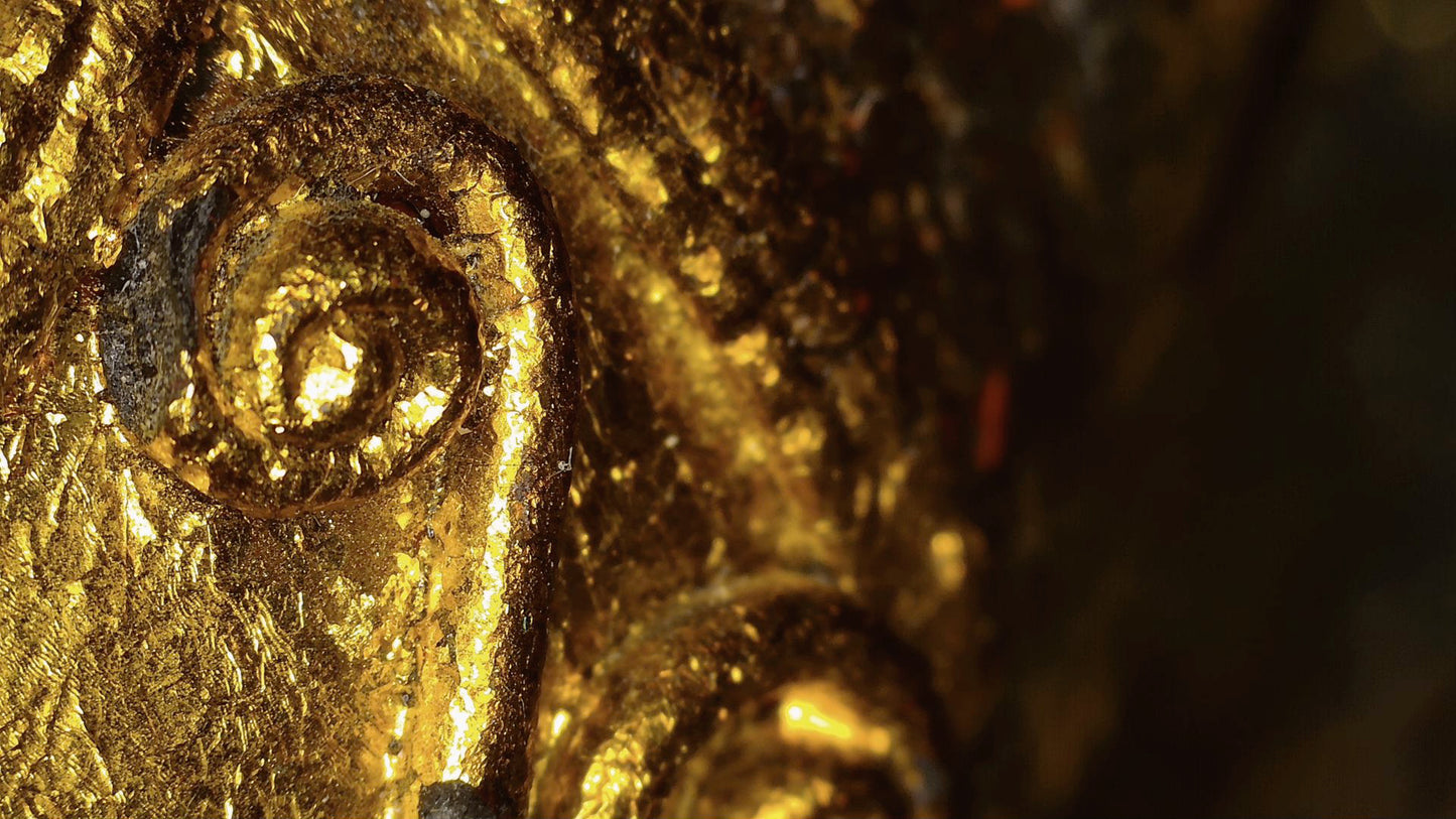 Mikroskopdetail von Blattgold und Reliefdekor an der birmanischen Skulptur