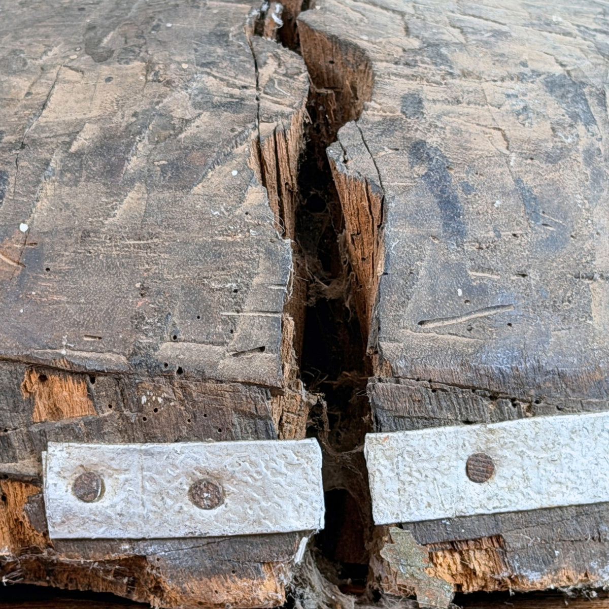 Birmanische Nat-Figur: Riss im Holzsockel mit Metallstreifen zur Reparatur