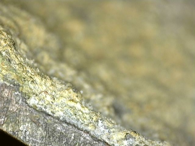 Mikroskopische Aufnahme von Cuprit und dunkler Oxidation auf einer antiken Brahma-Statue