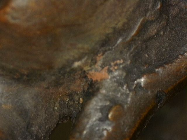 Mikroskopische Aufnahme der natürlichen Alterung eines Buddha aus Bronze mit Meditationsmudra