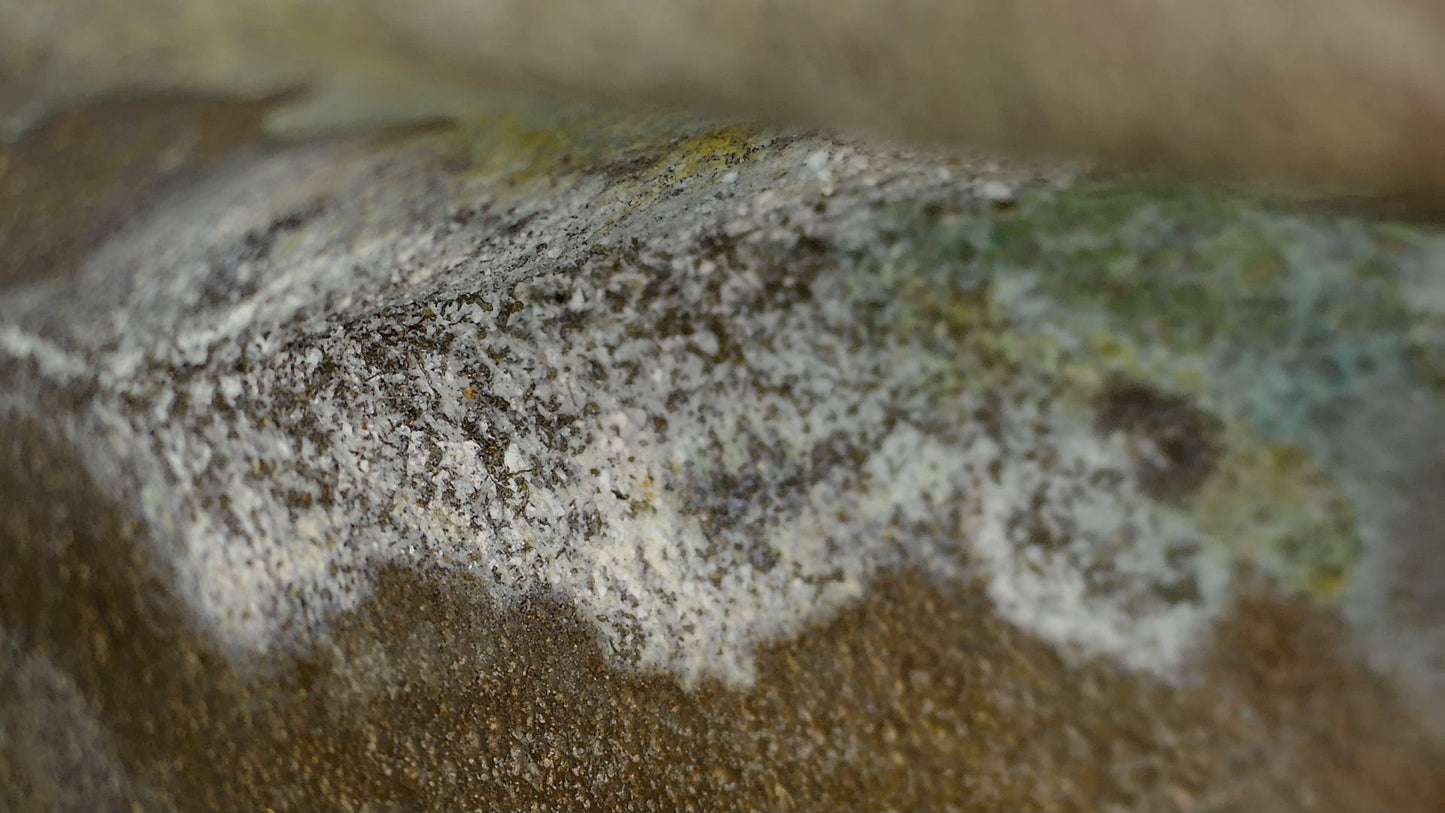 Innere Bronzeoberfläche mit hellen Ablagerungen und grüner Oxidation