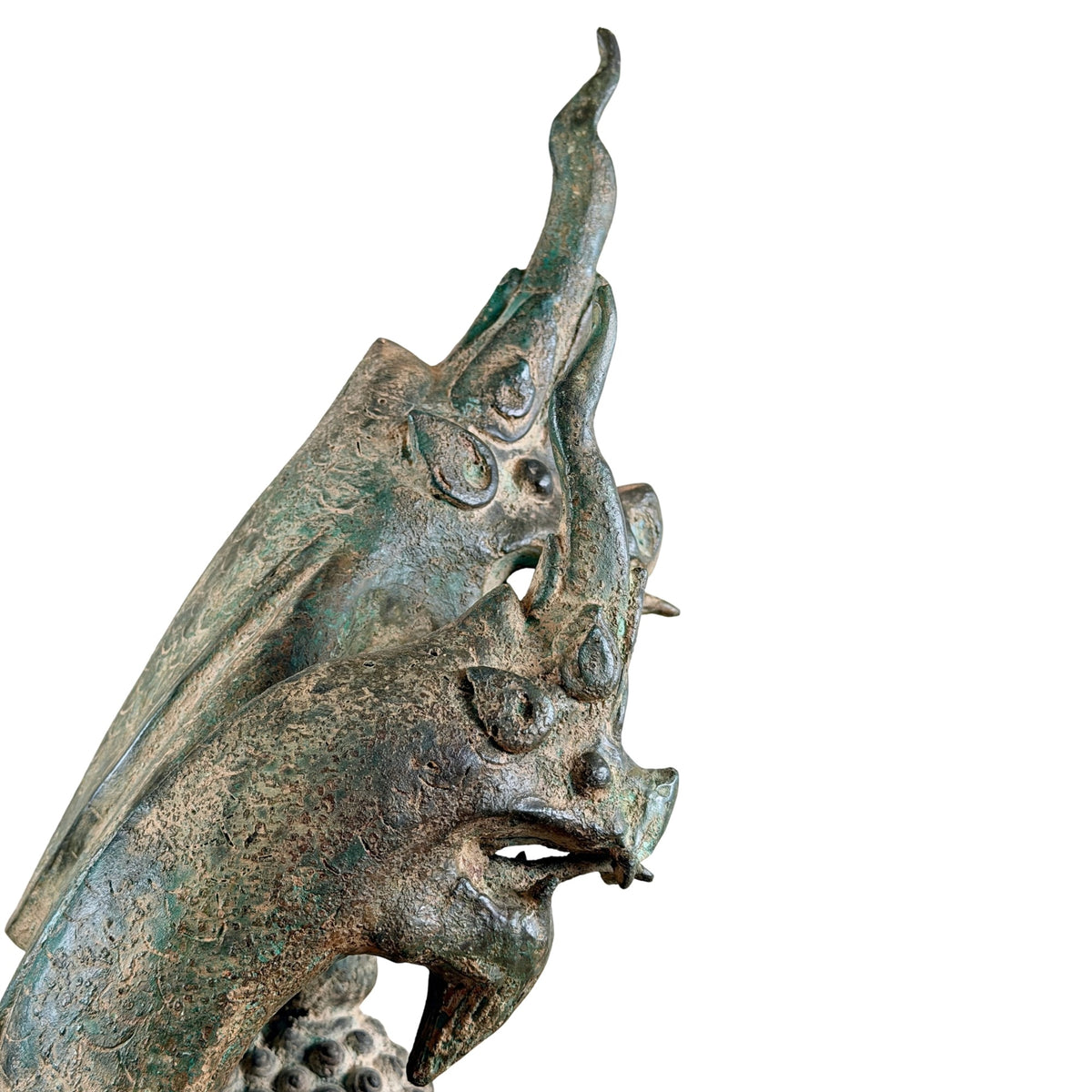 Profil eines Naga-Kopfes mit hoher Spitze, offenem Maul und verwitterter Bronzepatina