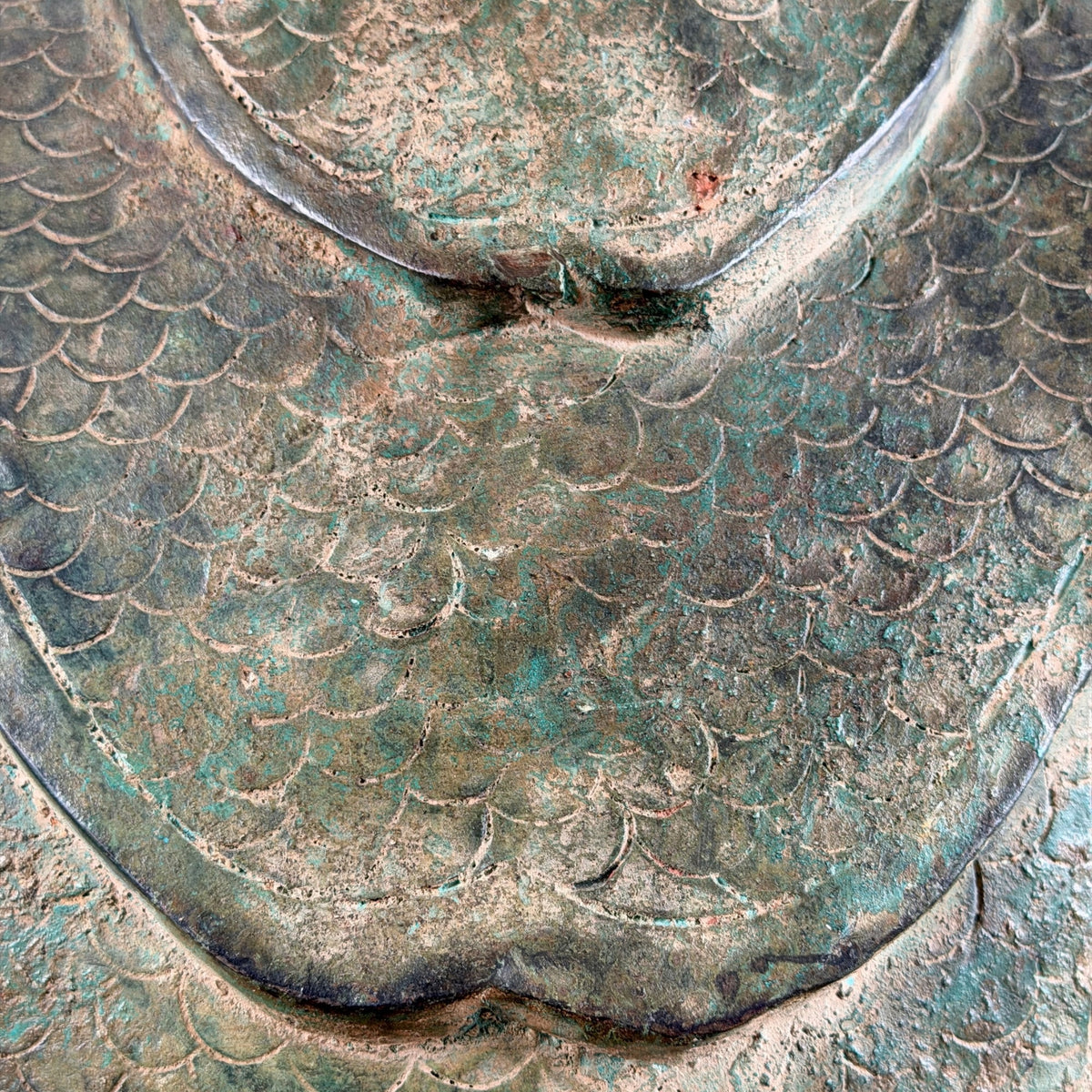Nahaufnahme des gravierten Schuppenmusters auf der Rückseite der Naga-Haube