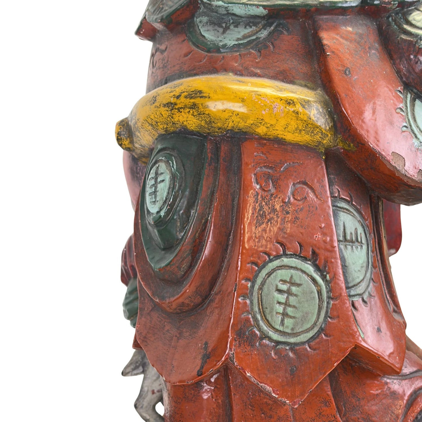 Makrodetail der dekorativen Medaillons auf Shoulaos Gewand, die die reiche Textur und Farbschichtung dieses Teakholzobjekts hervorheben.