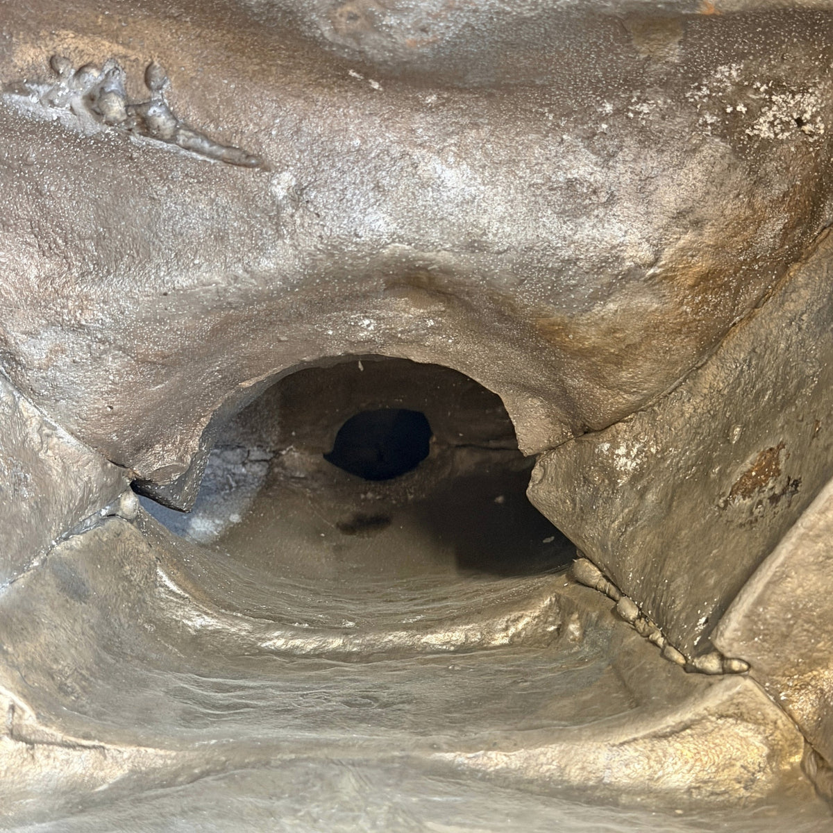 Die zentrale Öffnung im Inneren des Buddha mit unregelmäßigen Kanten und sichtbaren Nähten der verbundenen Teile.