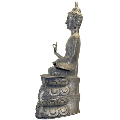 Linke Seitenansicht der vollständigen Buddhafigur: langer Gewandärmel, vorgestreckte Handgeste und vierstufiger Lotussockel.