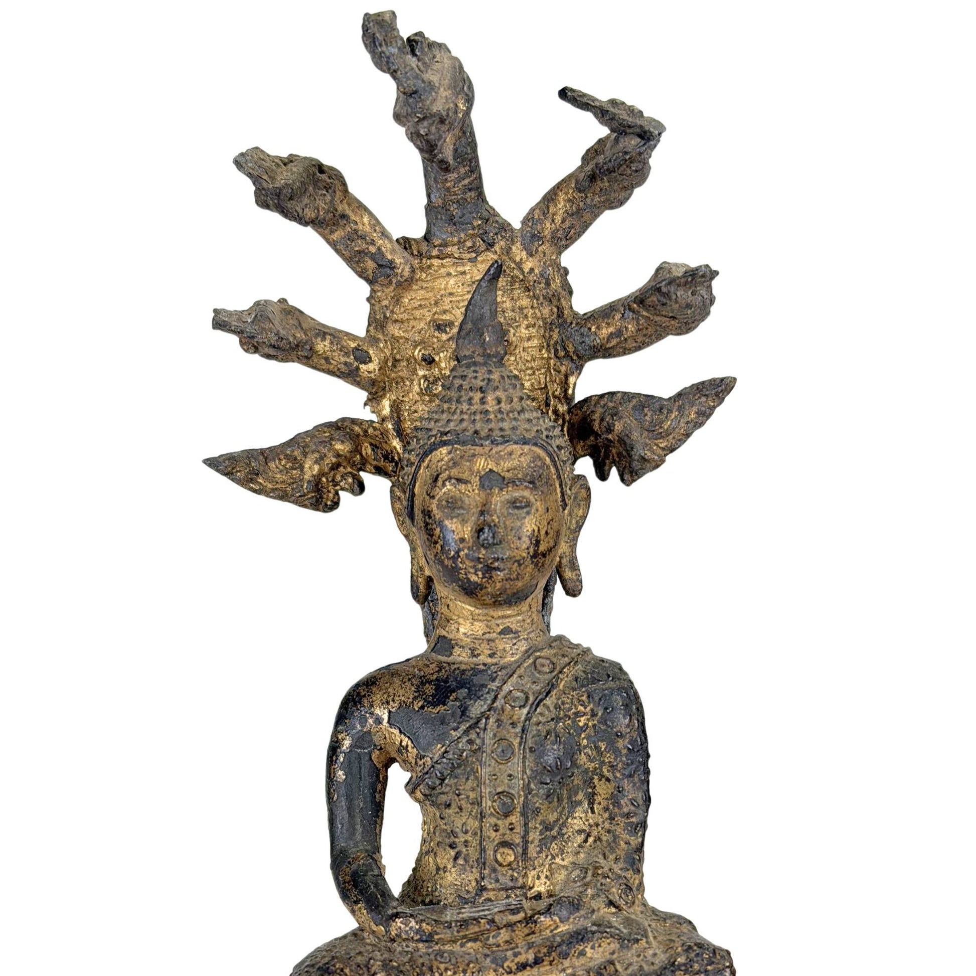 Nahaufnahme einer antiken, vergoldeten thailändischen Naga-Buddha-Statue mit gelassenem Gesichtsausdruck