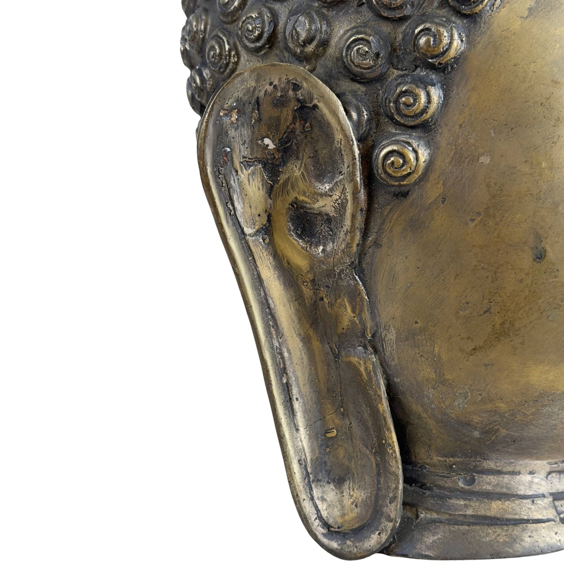 Detail des langen Ohrläppchens einer Buddha-Skulptur aus Bronze