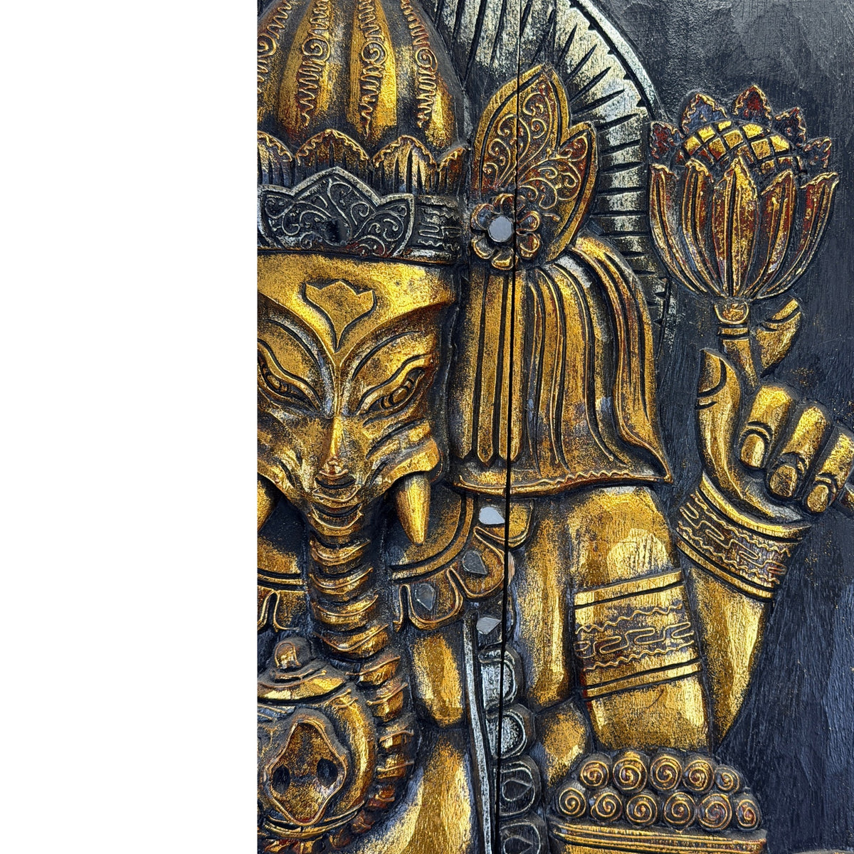 Lotusblüte in Ganeshas oberer linker Hand, darunter eine Schale; Kopf und Krone sind angeschnitten sichtbar.